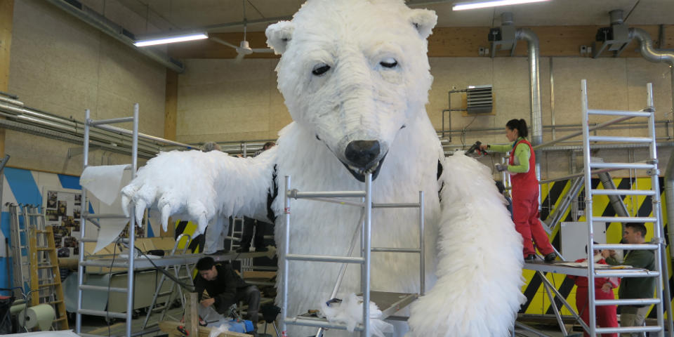 Picture of people working on a polar bear sculpture.