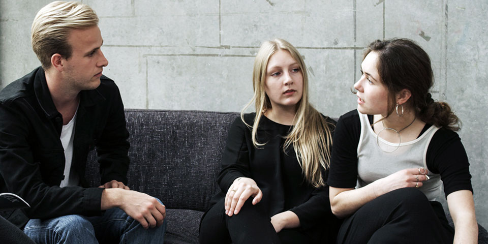three students on sofa
