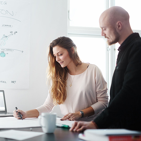 A man and a woman looking at a paper.
