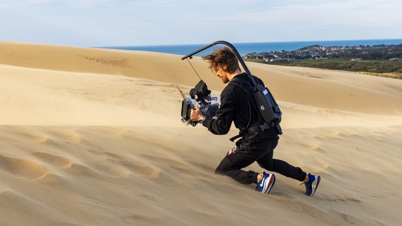 man filming in desert